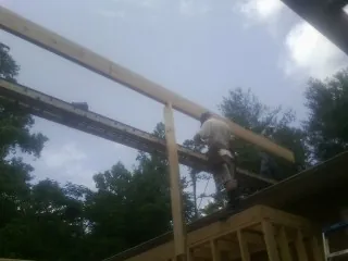 Carpenter setting a ridge beam over a new addition frame — Ice Dam Removal by Roofing Brothers in Speed