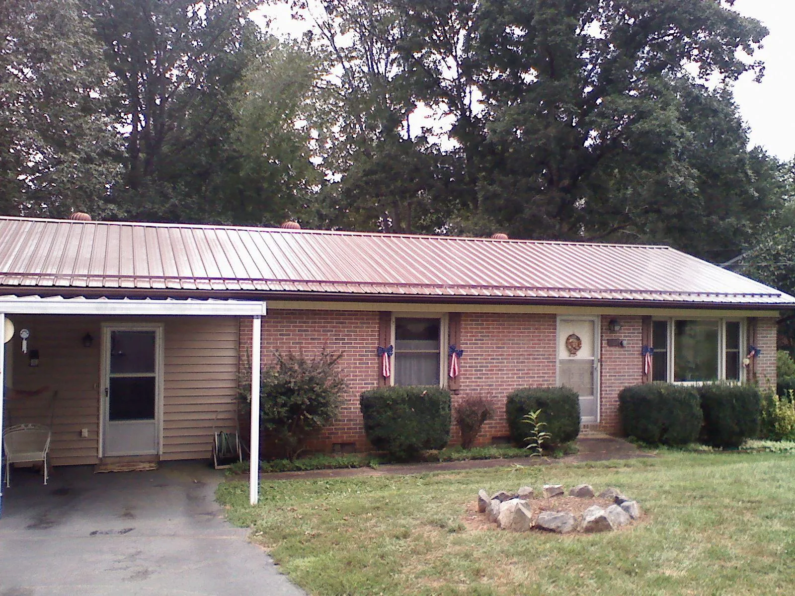 Bronze metal roof and carport on a brick ranch home — Roof Repair work by our crew in Speed